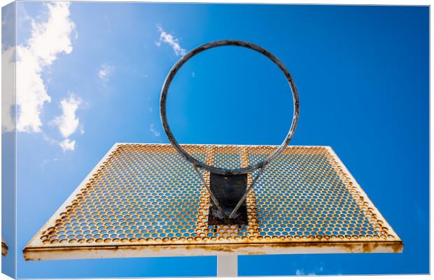 An old basketball basket outside a street with blue sky, copy space for text. Canvas Print by Joaquin Corbalan