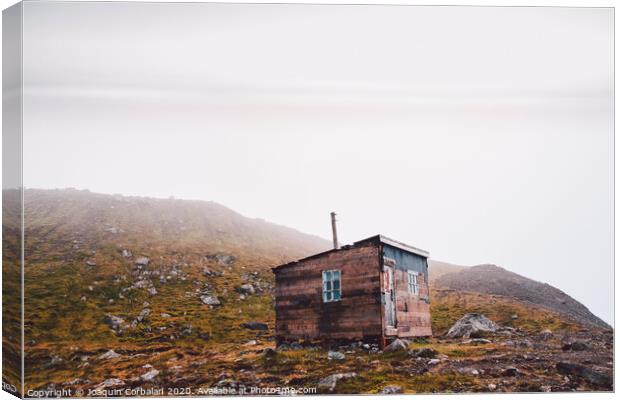 Small wooden hut on top of a mountain surrounded by fog in winter to seek solitude. Canvas Print by Joaquin Corbalan