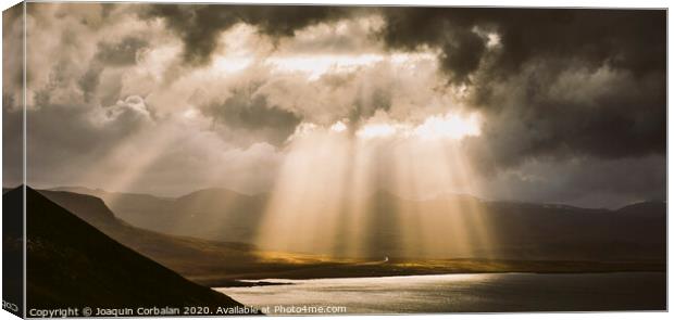 Sunbeams fall among the clouds in a lake between mountains. Canvas Print by Joaquin Corbalan