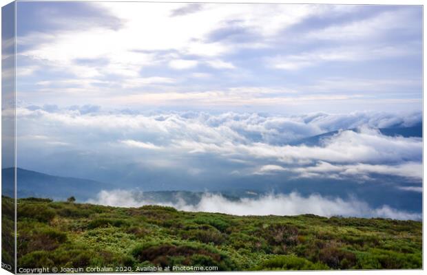 Scene of a winter cloudy sky from the top of a mountain peak. Canvas Print by Joaquin Corbalan
