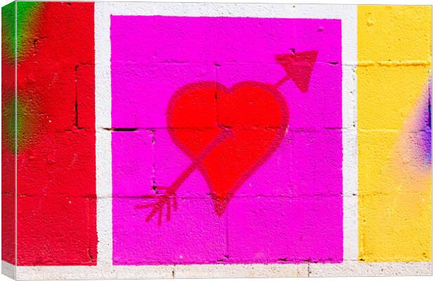 Heart pierced by a red arrow painted on a framed mural. Canvas Print by Joaquin Corbalan