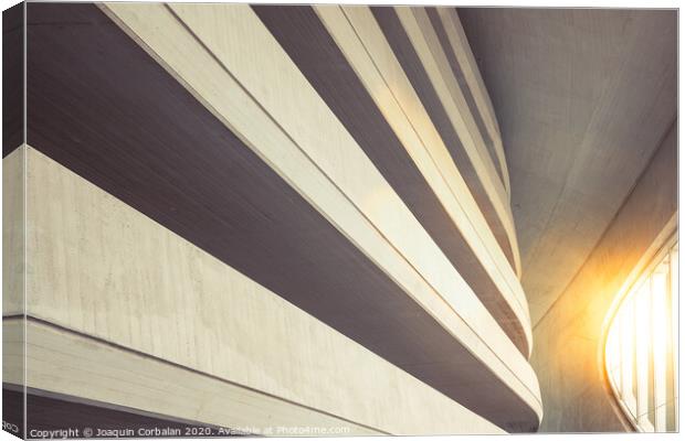 Warm tones background of the interior of a minimalist construction of rough textured walls and lines, illuminated with a sunbeam at sunset. Canvas Print by Joaquin Corbalan