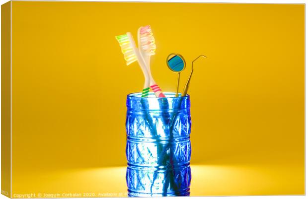 New plastic toothbrushes inside a glass, isolated on bright orange background, with copy space. Canvas Print by Joaquin Corbalan