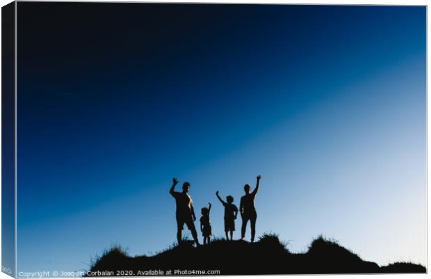 Silhouette of a happy family on top of a hill waving at sunset. Canvas Print by Joaquin Corbalan