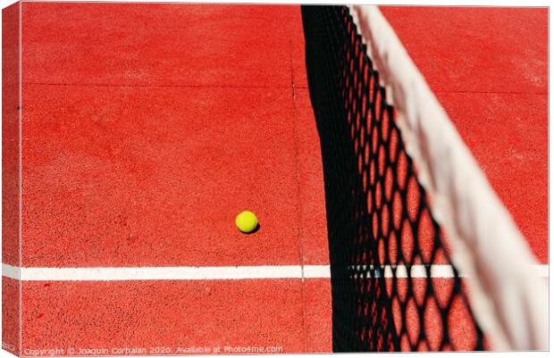 A tennis ball on the textured floor of a red court near the net after losing a match point. Canvas Print by Joaquin Corbalan