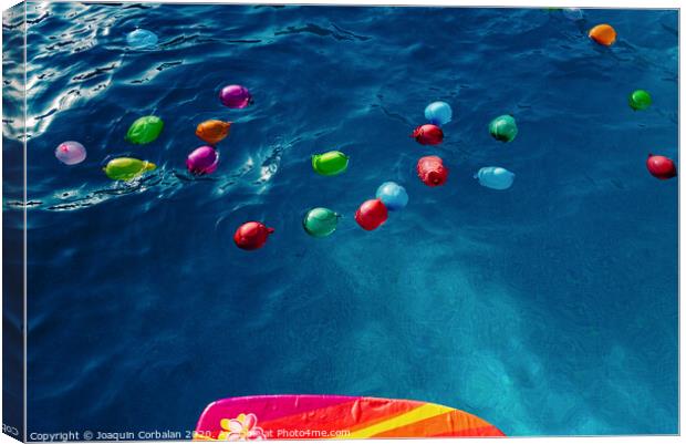 Group of many colorful plastic water balloons floating in the water of a pool to entertain their children on summer vacations. Canvas Print by Joaquin Corbalan