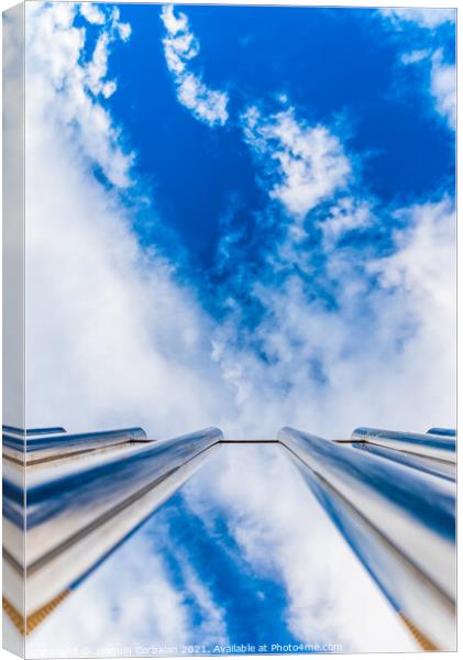 Fence with tall metal bars pointing to the blue sky with perspec Canvas Print by Joaquin Corbalan