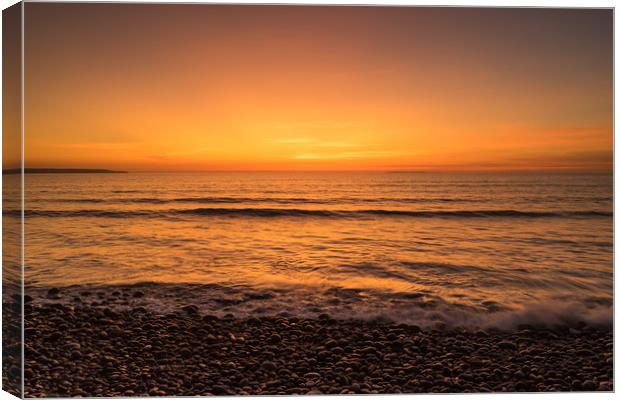 Waves on the sunset lit shoreline at Westward Ho Canvas Print by Tony Twyman