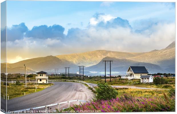 Road with mountains and wooden houses, Leknes. Canvas Print by RUBEN RAMOS