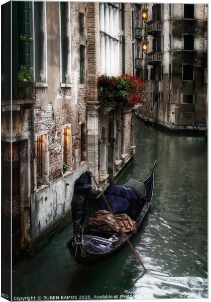 Man rowing a venetian gondola, Venice, Italy. Canvas Print by RUBEN RAMOS