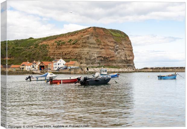 Commercial fishing boats moored in Staithes harbour on the North Yorkshire coast Canvas Print by Chris Yaxley