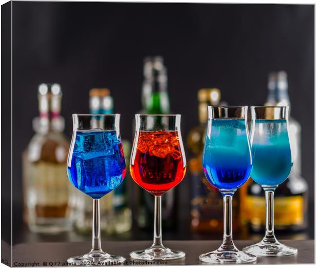 Colorful drink on the background of bottles in ori Canvas Print by Q77 photo