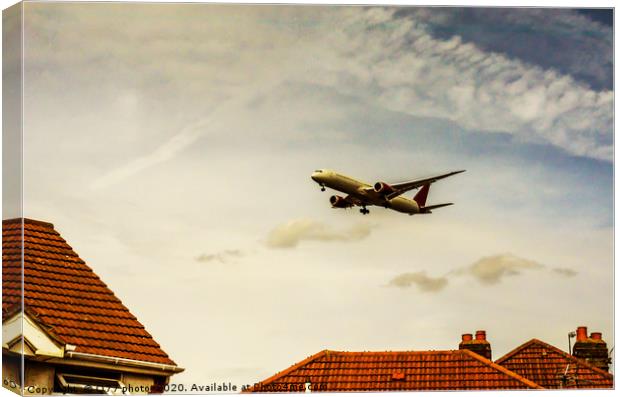 Passenger plane flying over the roofs of residenti Canvas Print by Q77 photo