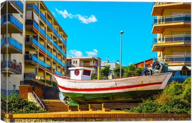 view of the promenade in the seaside town, in the middle of the roundabout old fishing boat Canvas Print by Q77 photo
