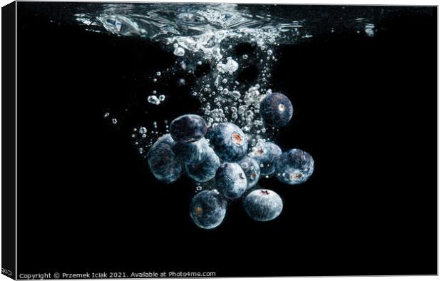 Blueberries splashing in water on black Canvas Print by Przemek Iciak