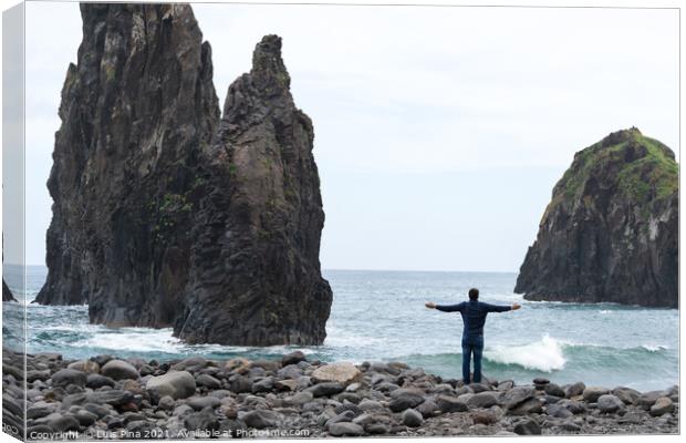 Man with arms wide open looking at Ribeira da Janela islet in Madeira Canvas Print by Luis Pina