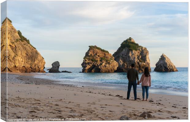 Couple holding hands on a wild empty beach in Ribeiro do Cavalo, Arrabida, Portugal Canvas Print by Luis Pina