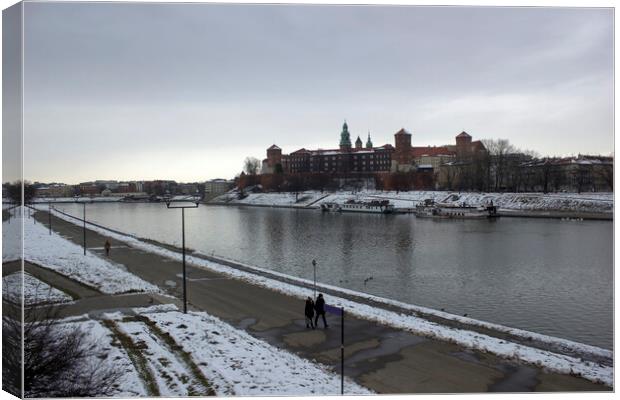 Krakow, Poland - January 29, 2015: Wide angle view of famous wawel castle covered with snow next to vistual river against cloudy sky Canvas Print by Arpan Bhatia
