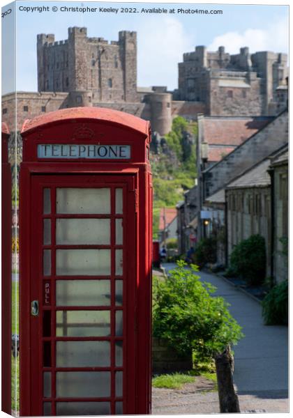 Red telephone box and Bamburgh Castle Canvas Print by Christopher Keeley