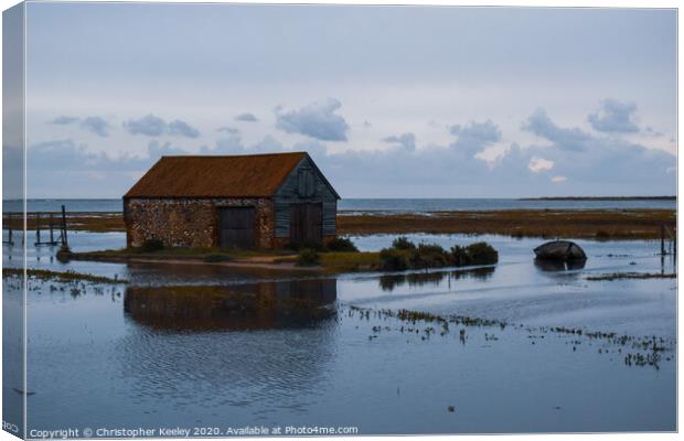North Norfolk coal barn surrounded by sea Canvas Print by Christopher Keeley