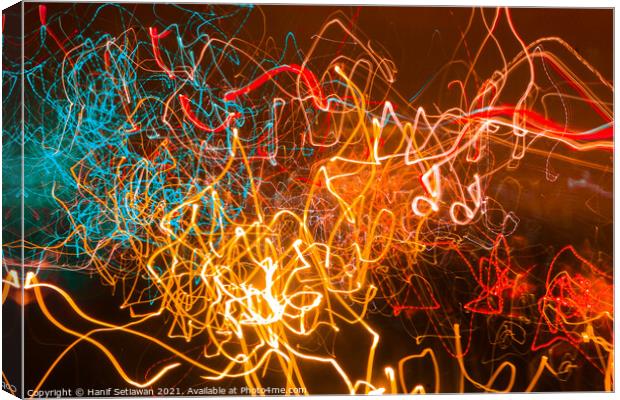 Abstract shapes of glowing swirled neon light Canvas Print by Hanif Setiawan