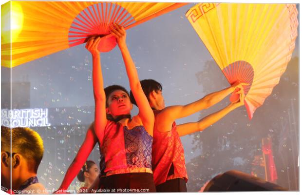 Dance performer raising arms with paper fans Canvas Print by Hanif Setiawan