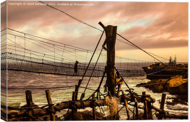 A man on a swinging rope foot bridge. Canvas Print by Hanif Setiawan