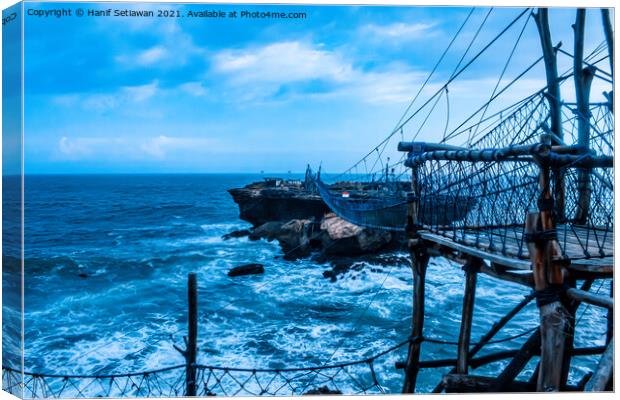 Swinging rope foot bridge to a rock island Canvas Print by Hanif Setiawan