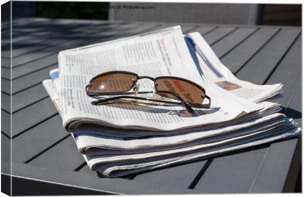 Pile of newspapers and sunglasses Canvas Print by aurélie le moigne