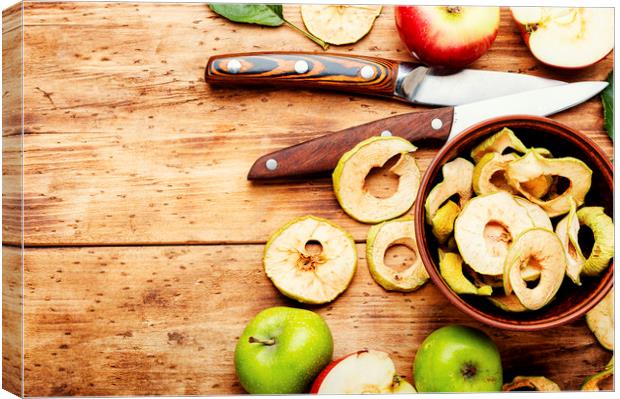 Tasty apple chips on old wooden table Canvas Print by Mykola Lunov Mykola