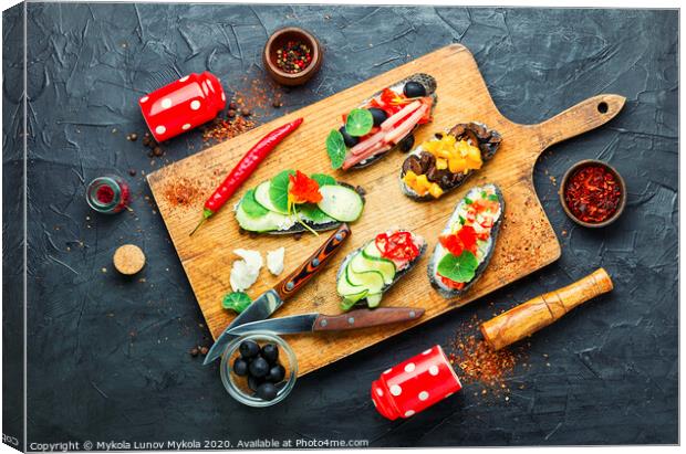 Set of bruschetta on cutting board Canvas Print by Mykola Lunov Mykola