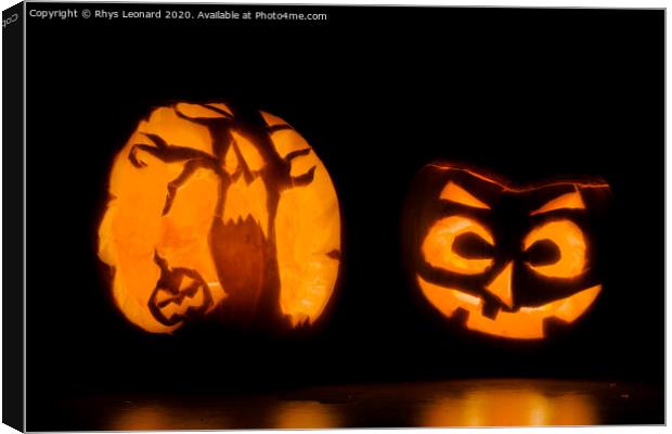 Two intricately carved halloween pumpkins lit by candle tea lights Canvas Print by Rhys Leonard