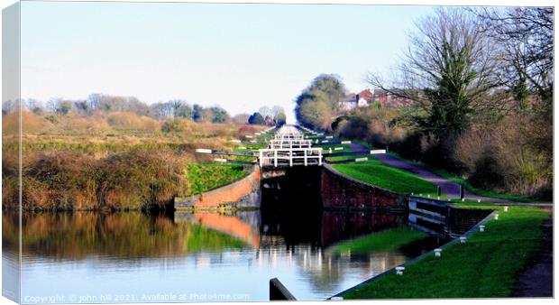 Caen hill canal locks at Devizes in Wiltshire, UK. Canvas Print by john hill