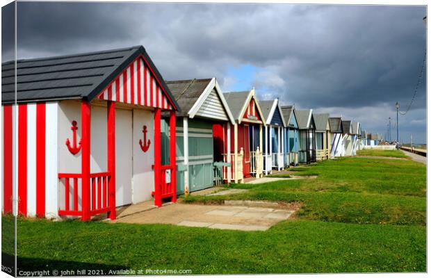 Stormy Skies over beach huts. Canvas Print by john hill