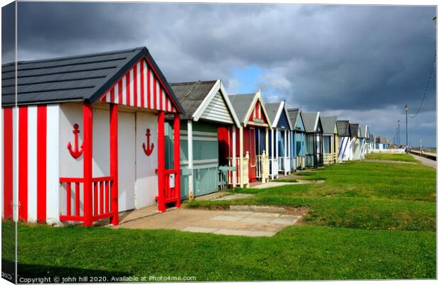 Stormy skies over beach huts in Lincolnshire. Canvas Print by john hill