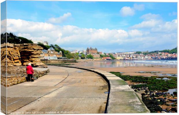 Walking the promenade towards Scarborough in Yorkshire. Canvas Print by john hill