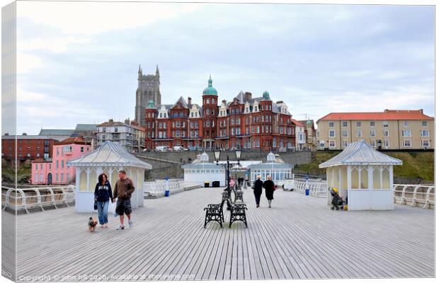 The boardwalk and town from the pier at Cromer in Norfolk.  Canvas Print by john hill