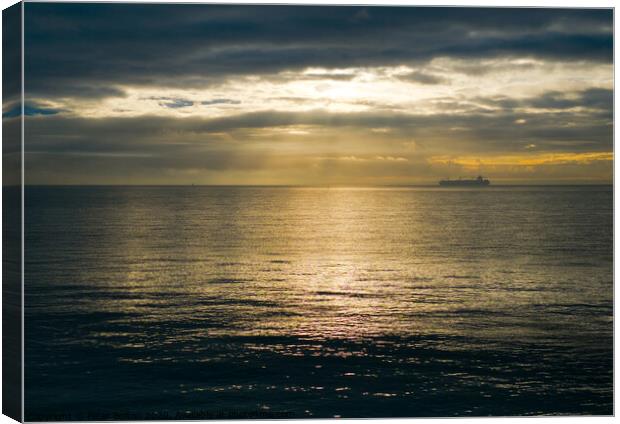 Wide view of The Thames Estuary off the Essex coast with changeable weather on the horizon. A ship on the horizon makes its way downriver. Canvas Print by Peter Bolton