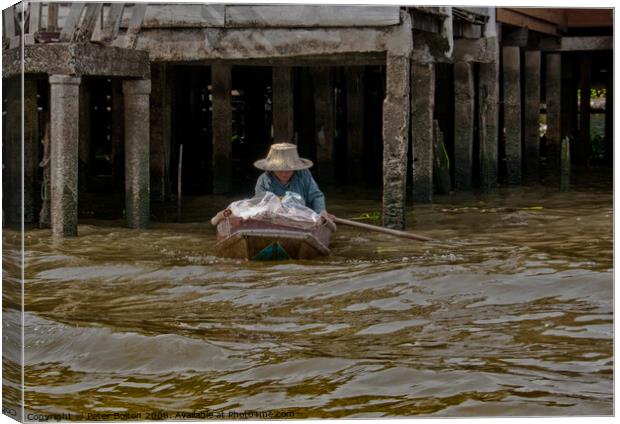 A local resident in her day to day mode of transport on a canal in Bangkok, Thailand. Canvas Print by Peter Bolton