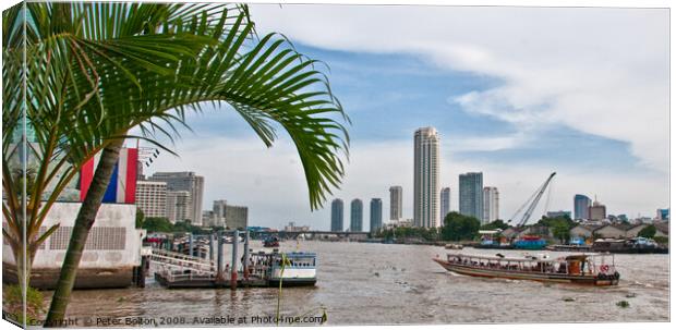 A view of ferries and landing stages on the Chao Phraya River, Bangkok, Thailand. Canvas Print by Peter Bolton