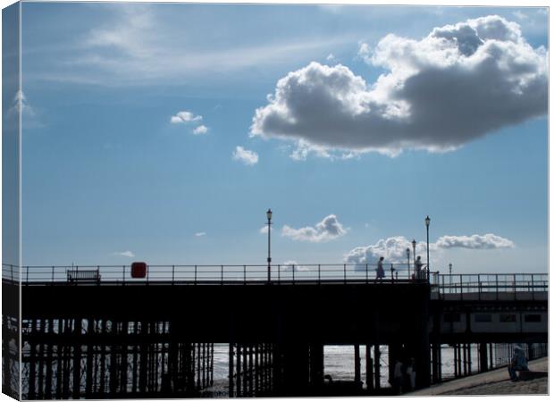 Part of the walkway in silhouette at Southend Pier, Essex, UK, with isolated clouds overhead. Canvas Print by Peter Bolton