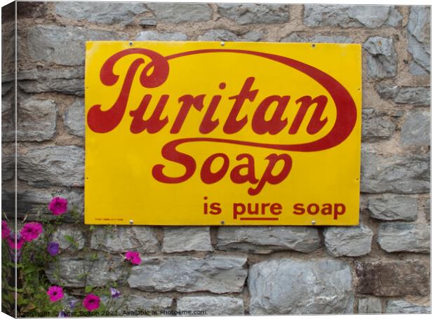 Enamel sign advertising Puritan soap on a wall in Buckfastleigh, Devon. Canvas Print by Peter Bolton