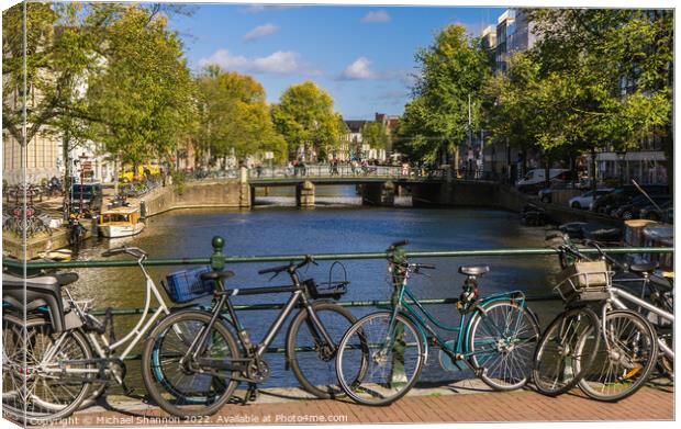 Bridge, canal view and bikes - Amsterdam Canvas Print by Michael Shannon