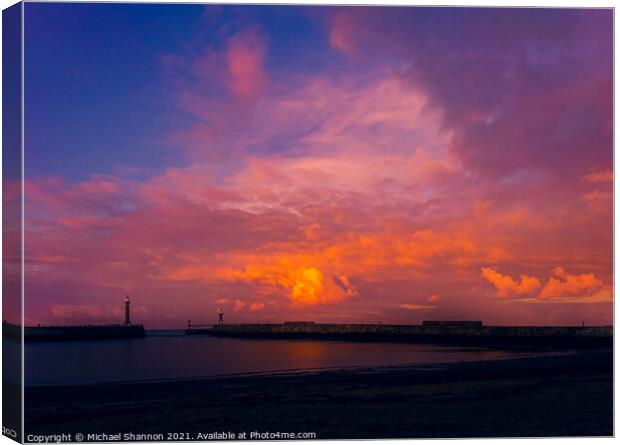 Colourful sky over the piers at Whitby in North Yo Canvas Print by Michael Shannon