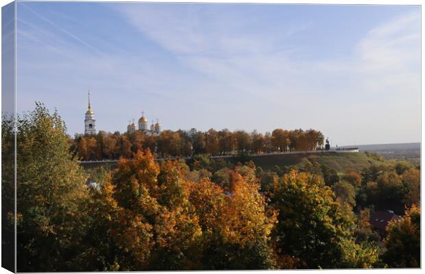 Stunning autumn landscape, top view, sun and blue sky, yellow trees, white Church, Golden domes, green grass, red leaves.  Canvas Print by Karina Osipova