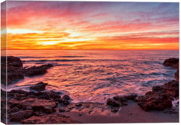 Photograph with a reddish sunrise in a small cove of la renega in Oropesa Canvas Print by Vicen Photo
