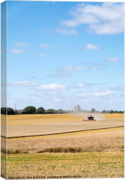 Combine harvester reaping a wheat crop Canvas Print by Allan Bell