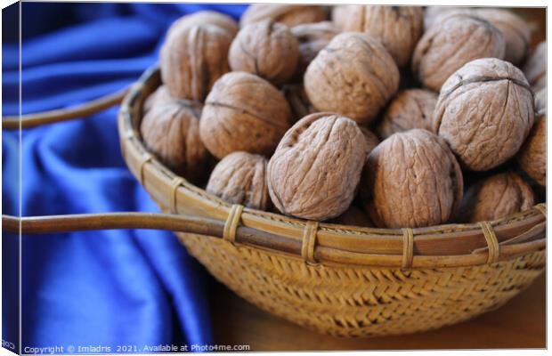 Walnuts in a basket with blue tablecloth Canvas Print by Imladris 