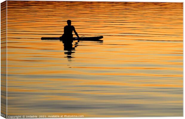 Silhouetted paddle boarder peaceful sunset Canvas Print by Imladris 