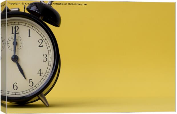 Analog alarm clock displaying five o'clock on a yellow background with copy space Canvas Print by Kristof Bellens